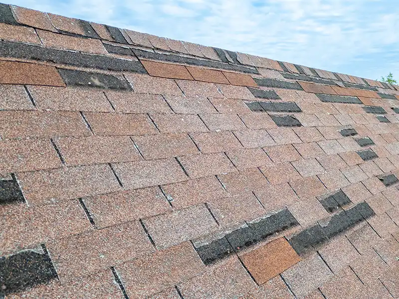 Roof with missing shingles due to strong winds